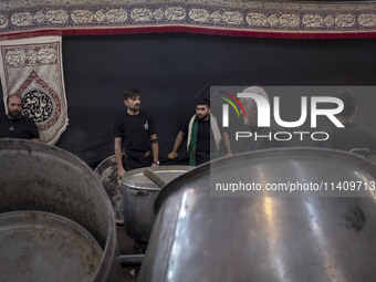 Iraqi men living in Iran are preparing donated meals for worshippers during a religious rally to commemorate Tasoua, in Dolatabad neighborho...