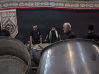 Iraqi men living in Iran are preparing donated meals for worshippers during a religious rally to commemorate Tasoua, in Dolatabad neighborho...