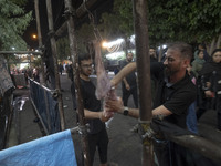 An Iraqi man living in Iran is preparing meat for baking donated meals for worshippers during a religious rally to commemorate Tasoua, in Do...