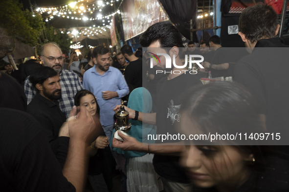 An Iraqi man living in Iran is serving donated Arabian coffee for worshippers during a religious rally to commemorate Tasoua, in Dolatabad n...