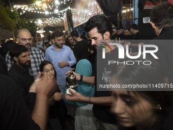 An Iraqi man living in Iran is serving donated Arabian coffee for worshippers during a religious rally to commemorate Tasoua, in Dolatabad n...