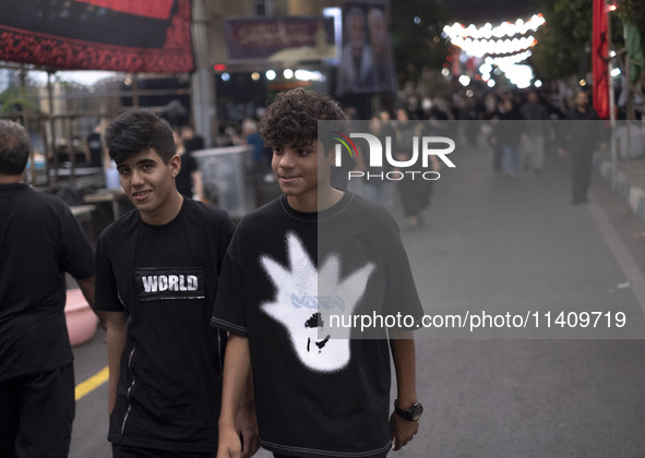 Two young worshippers are walking together while participating in a religious rally to commemorate Tasoua, in Dolatabad neighborhood in sout...