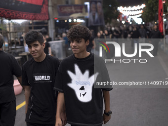 Two young worshippers are walking together while participating in a religious rally to commemorate Tasoua, in Dolatabad neighborhood in sout...