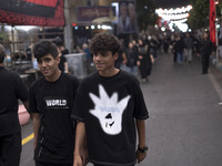 Two young worshippers are walking together while participating in a religious rally to commemorate Tasoua, in Dolatabad neighborhood in sout...