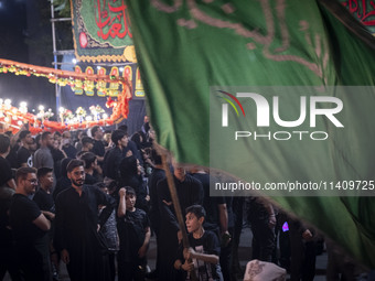 A young Iraqi boy is holding a religious flag while participating in a religious rally to commemorate Tasoua in the Dolatabad neighborhood i...