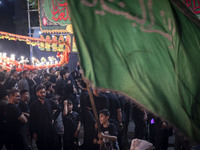 A young Iraqi boy is holding a religious flag while participating in a religious rally to commemorate Tasoua in the Dolatabad neighborhood i...