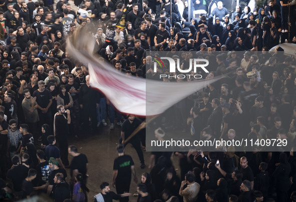 An Iraqi worshipper living in Iran is waving a religious flag during a religious rally to commemorate Tasoua, in Dolatabad neighborhood in s...