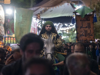 An Iraqi man living in Iran is riding a horse while performing in a religious rally to commemorate Tasoua, in Dolatabad neighborhood in sout...