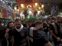 An Iraqi worshipper living in Iran is carrying a religious symbol while participating in a religious rally to commemorate Tasoua, in Dolatab...