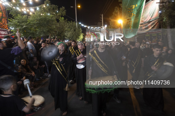 Iraqi worshippers living in Iran are performing in a religious rally to commemorate Tasoua in the Dolatabad neighborhood in southern Tehran,...