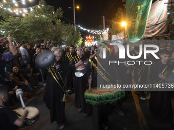 Iraqi worshippers living in Iran are performing in a religious rally to commemorate Tasoua in the Dolatabad neighborhood in southern Tehran,...