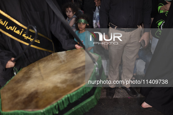 A young girl is wearing a religious headband and is participating in a religious rally to commemorate Tasoua in Dolatabad neighborhood in so...