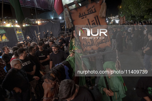 A young Iraqi boy living in Iran is riding a horse while performing in a religious rally to commemorate Tasoua, in Dolatabad neighborhood in...