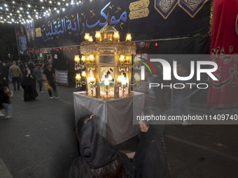 A religious symbol is being pictured during a religious rally to commemorate Tasoua in the Dolatabad neighborhood in southern Tehran, Iran,...