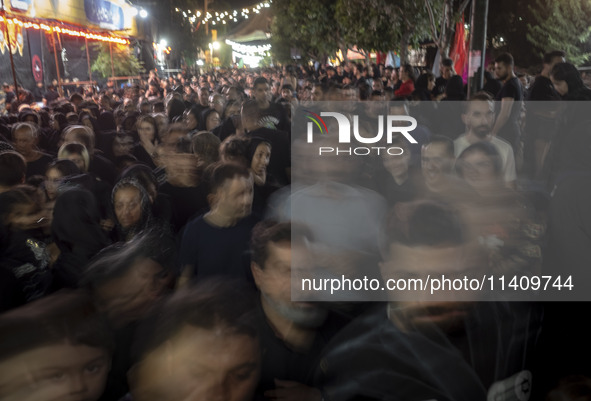 Worshippers are walking along a street while participating in a religious rally to commemorate Tasoua, in Dolatabad neighborhood in southern...