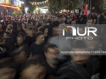 Worshippers are walking along a street while participating in a religious rally to commemorate Tasoua, in Dolatabad neighborhood in southern...