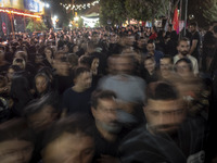 Worshippers are walking along a street while participating in a religious rally to commemorate Tasoua, in Dolatabad neighborhood in southern...