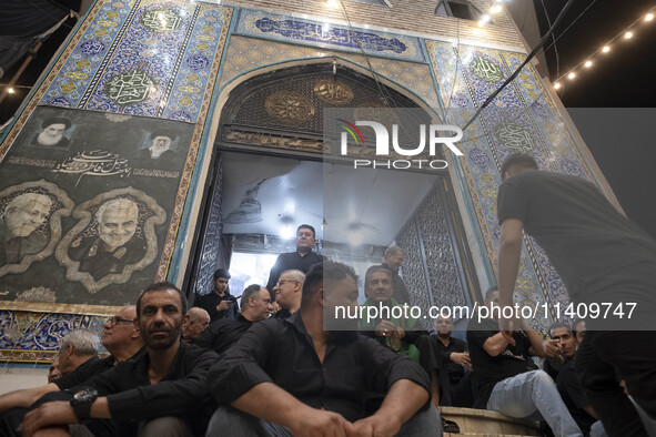 Iraqi men living in Iran are sitting just outside a mosque while they are participating in a religious rally to commemorate Tasoua, in Dolat...