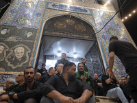 Iraqi men living in Iran are sitting just outside a mosque while they are participating in a religious rally to commemorate Tasoua, in Dolat...