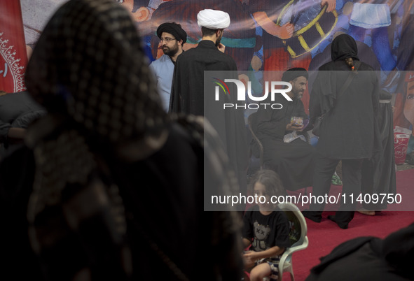 Clerics are standing together while one of them is talking to a young veiled girl during a religious rally to commemorate Tasoua in Dolataba...