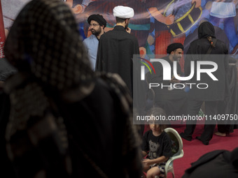 Clerics are standing together while one of them is talking to a young veiled girl during a religious rally to commemorate Tasoua in Dolataba...