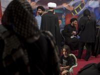 Clerics are standing together while one of them is talking to a young veiled girl during a religious rally to commemorate Tasoua in Dolataba...