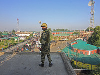 An Indian paramilitary soldier is keeping vigil from the top of a building as thousands of Shia Muslims are attending the mourning processio...