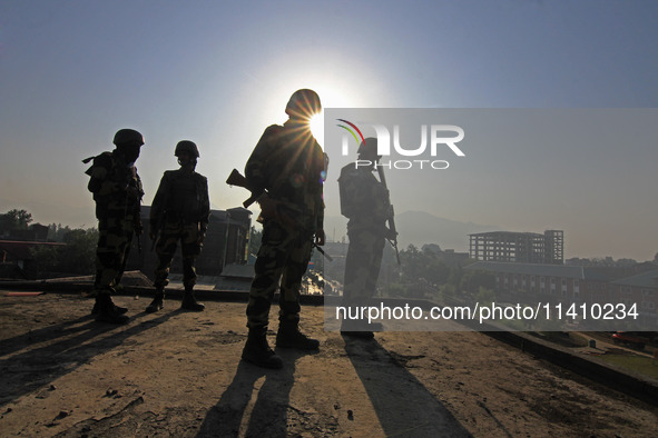 Indian paramilitary soldiers are keeping vigil from the top of a building as thousands of Shia Muslims are attending the mourning procession...