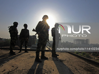 Indian paramilitary soldiers are keeping vigil from the top of a building as thousands of Shia Muslims are attending the mourning procession...