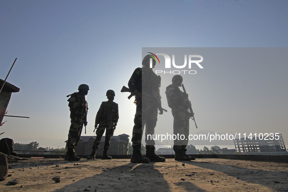 Indian paramilitary soldiers are keeping vigil from the top of a building as thousands of Shia Muslims are attending the mourning procession...