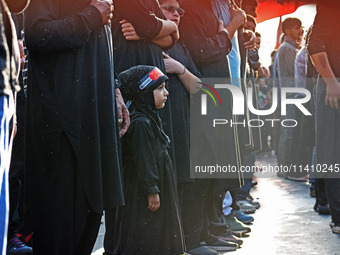 A girl is participating in the mourning procession to commemorate the martyrdom of Prophet Muhammad's grandson Imam Hussein (Husayn Ibn Ali)...