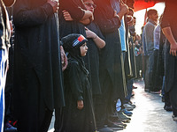 A girl is participating in the mourning procession to commemorate the martyrdom of Prophet Muhammad's grandson Imam Hussein (Husayn Ibn Ali)...