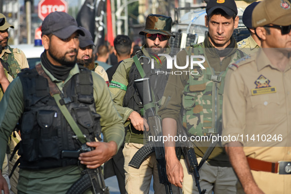 Indian policemen are patrolling the street as thousands of Shia Muslims are attending the mourning procession to commemorate the martyrdom o...