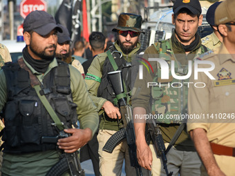 Indian policemen are patrolling the street as thousands of Shia Muslims are attending the mourning procession to commemorate the martyrdom o...