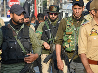 Indian policemen are patrolling the street as thousands of Shia Muslims are attending the mourning procession to commemorate the martyrdom o...