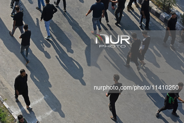 Kashmiri Shia mourners are walking as thousands of Shia Muslims are attending the mourning procession to commemorate the martyrdom of Prophe...