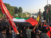 Shia mourners are carrying the Palestine flag as thousands are attending the mourning procession to commemorate the martyrdom of Prophet Muh...