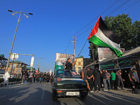 A Shia mourner is carrying a Palestine flag as thousands of Shia Muslims are attending the mourning procession to commemorate the martyrdom...