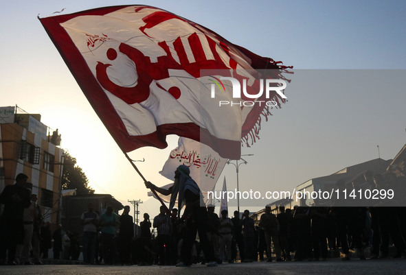 A Kashmiri Shiite Muslim mourner is waving a religious flag during a Muharram procession on the eighth day of Ashura in Srinagar, Jammu and...