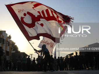 A Kashmiri Shiite Muslim mourner is waving a religious flag during a Muharram procession on the eighth day of Ashura in Srinagar, Jammu and...