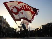 A Kashmiri Shiite Muslim mourner is waving a religious flag during a Muharram procession on the eighth day of Ashura in Srinagar, Jammu and...