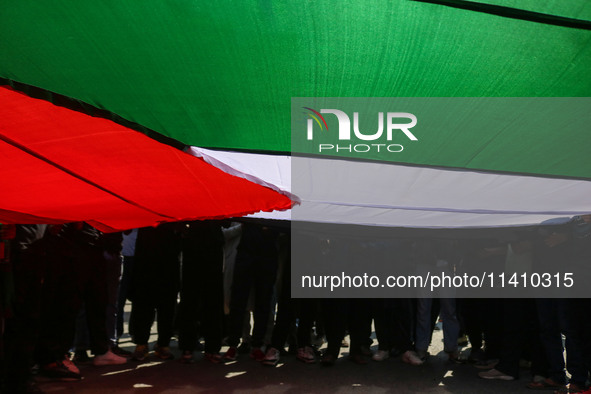 Kashmiri Shiite Muslim mourners are carrying a Palestinian flag and shouting anti-Israel and anti-US slogans as they take part in a Muharram...