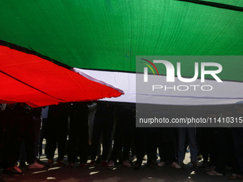 Kashmiri Shiite Muslim mourners are carrying a Palestinian flag and shouting anti-Israel and anti-US slogans as they take part in a Muharram...