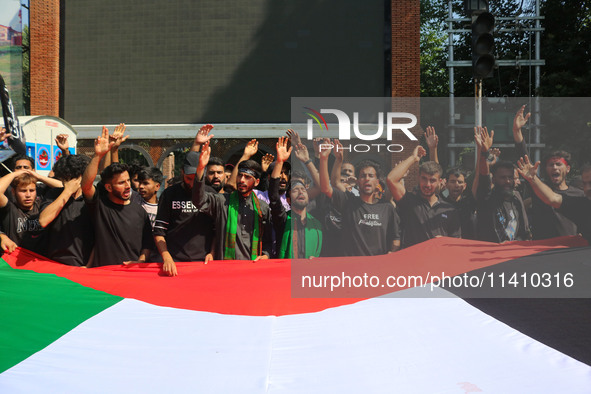 Kashmiri Shiite Muslim mourners are carrying a Palestinian flag and shouting anti-Israel and anti-US slogans as they take part in a Muharram...