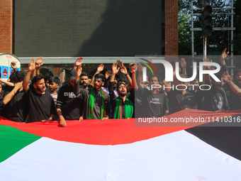 Kashmiri Shiite Muslim mourners are carrying a Palestinian flag and shouting anti-Israel and anti-US slogans as they take part in a Muharram...