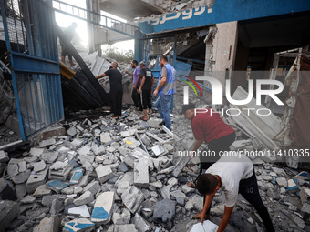 People are checking the destruction at a school run by the UN Relief and Works Agency for Palestine Refugees (UNRWA) that was previously hit...