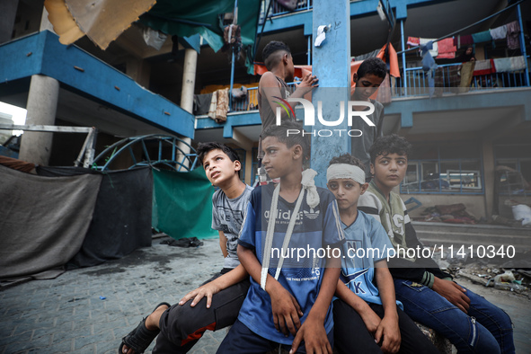 Wounded Palestinians are sitting inside a school run by the UN Relief and Works Agency for Palestine Refugees (UNRWA) that was previously hi...