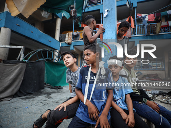 Wounded Palestinians are sitting inside a school run by the UN Relief and Works Agency for Palestine Refugees (UNRWA) that was previously hi...