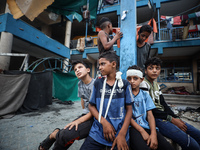 Wounded Palestinians are sitting inside a school run by the UN Relief and Works Agency for Palestine Refugees (UNRWA) that was previously hi...