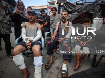 Wounded Palestinians are sitting inside a school run by the UN Relief and Works Agency for Palestine Refugees (UNRWA) that was previously hi...